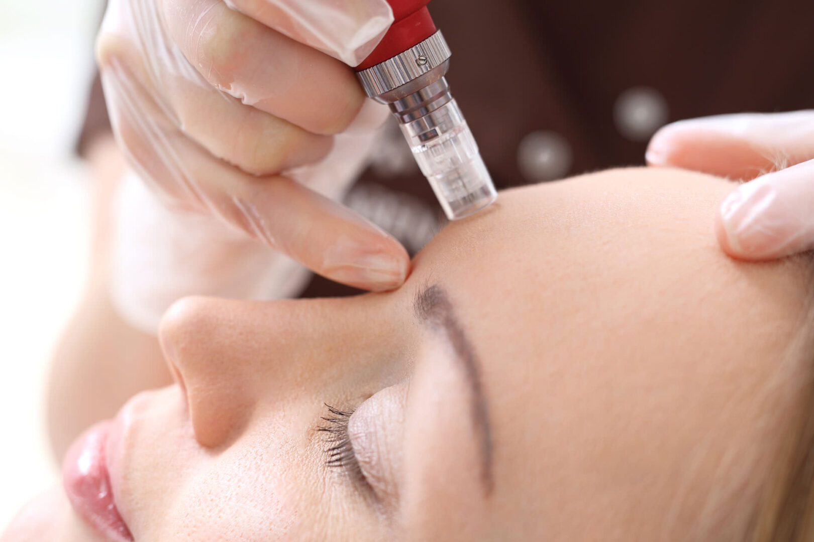 A person getting their face waxed with an electric device.