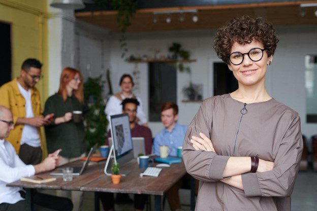 A woman standing in front of other people.