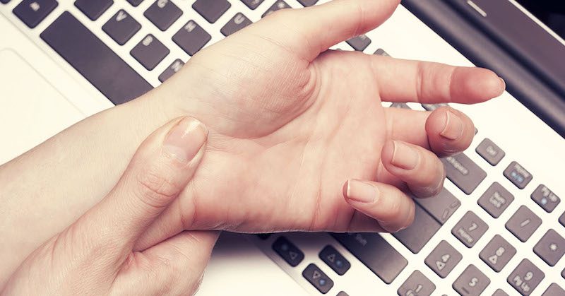 A person 's hands on top of a keyboard.