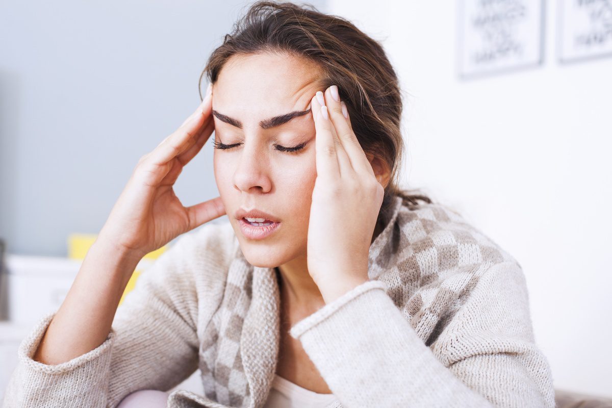 A woman with her hands on her head.